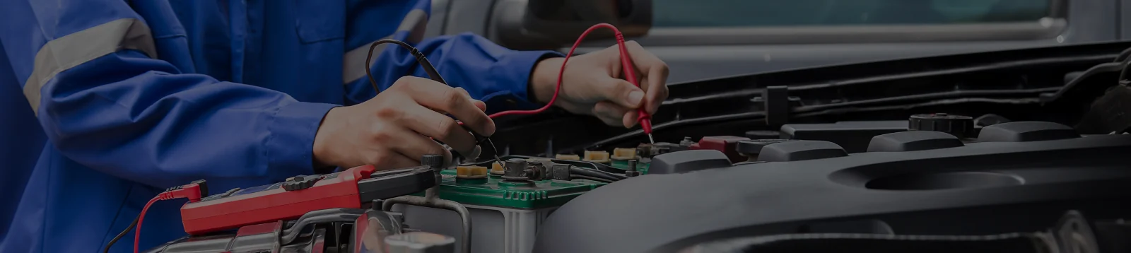 Automehaničar provjerava napon na akumulatoru vozila