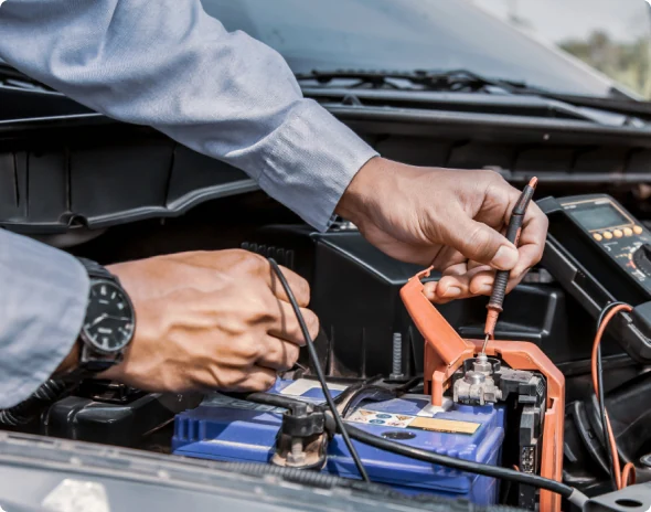Majstor provjerava napon na akumulatoru koji je spojen sa vozilom